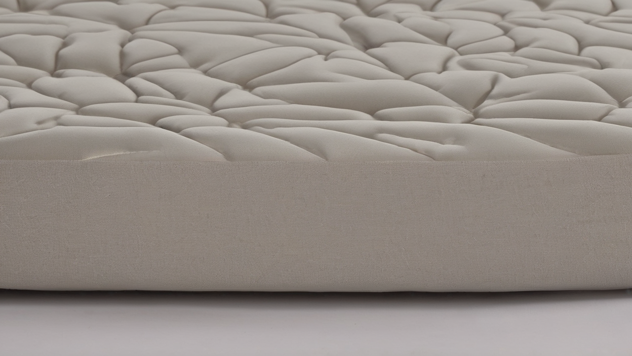 Przekrój nausznika pokazujący warstwową budowę z pianką memory foam i oddychającym materiałem zewnętrznym